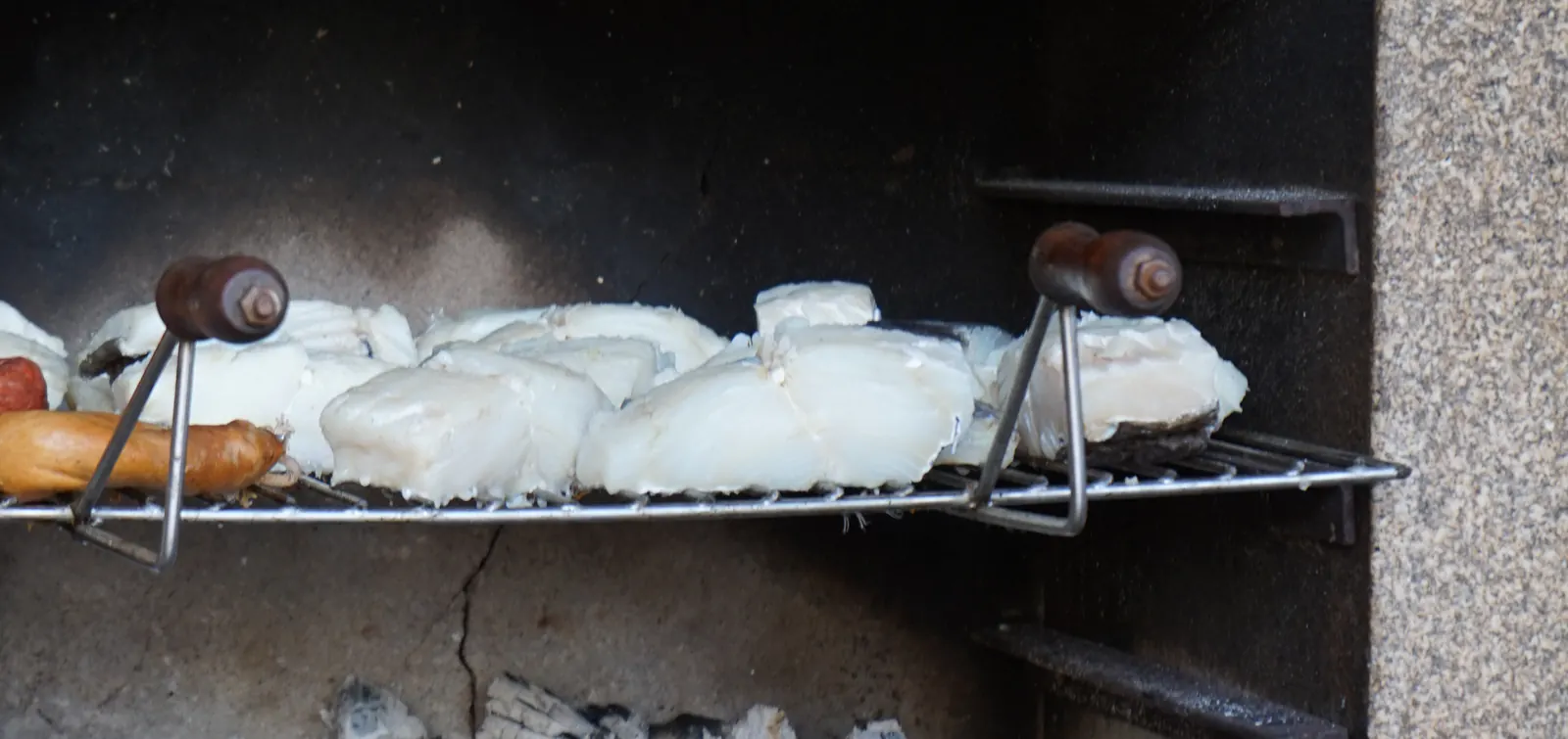 Peixe na brasa, preparado na grelha de pedra da quinta