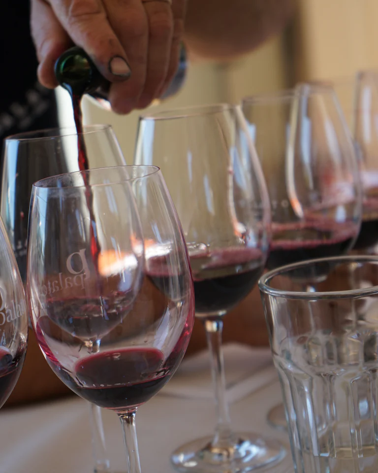 Red wine being poured into Palato glasses at the table